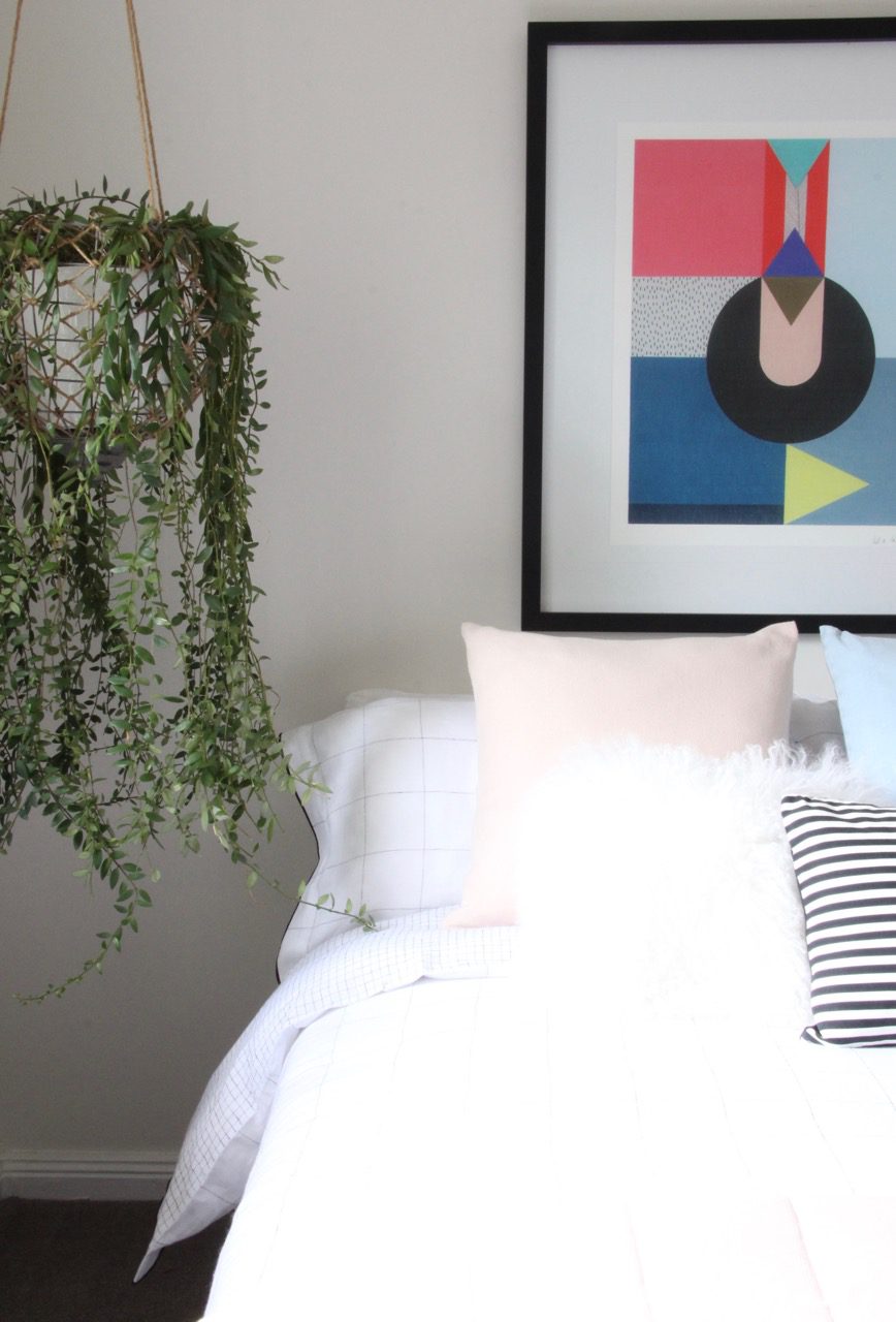 Colourful bedroom styling with artwork and plants